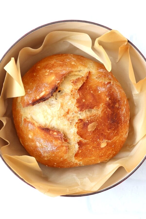 Loaf of crusty artisan bread in dutch oven.