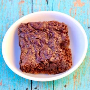 Black bean brownie cut into a square on small white dish.