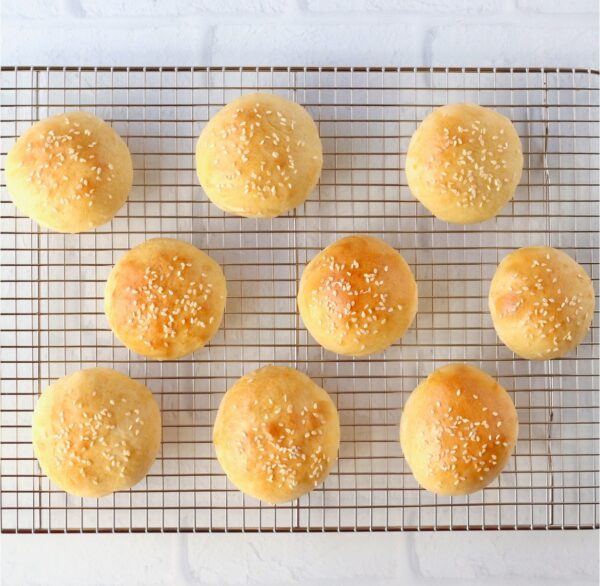 Baked homemade slider buns cooling on wire rack.