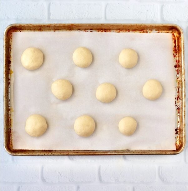 Dough balls for burger slider buns on cookie sheet.