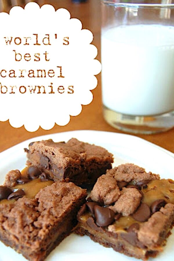 Three chocolate caramel brownies on plate with glass of milk in background.