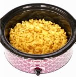 Crock pot filled with creamy macaroni and cheese.