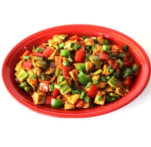 Kung Pao Chicken with bell peppers and green onions on platter.