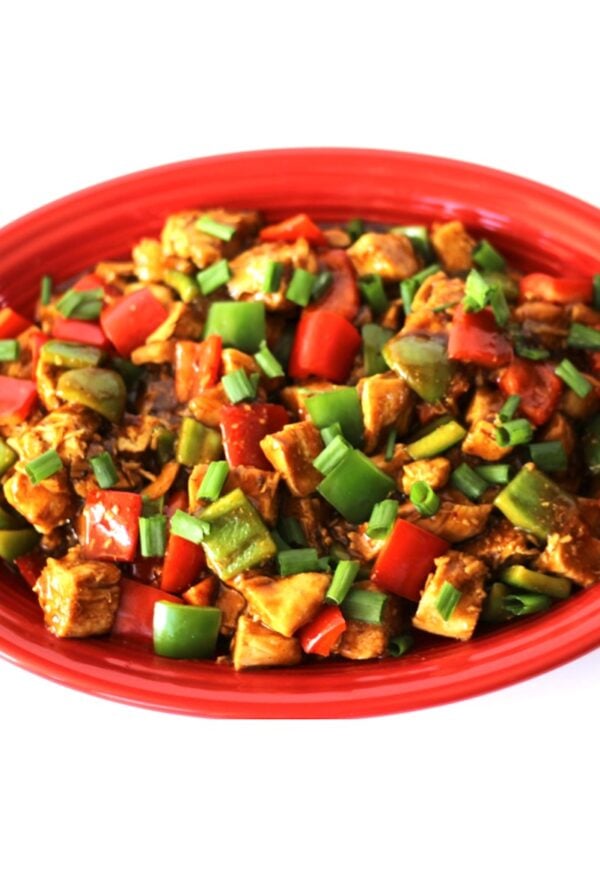 Kung Pao Chicken with bell peppers and green onions on platter.