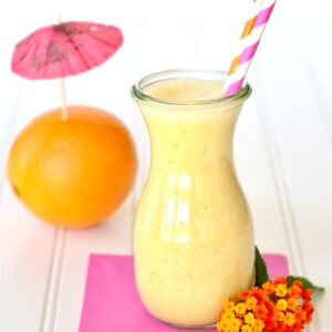 Orange Julius in jar with straws, and orange in the background.
