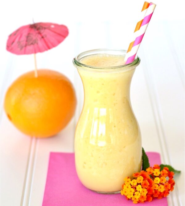 Orange Julius in jar with straws, and orange in the background.