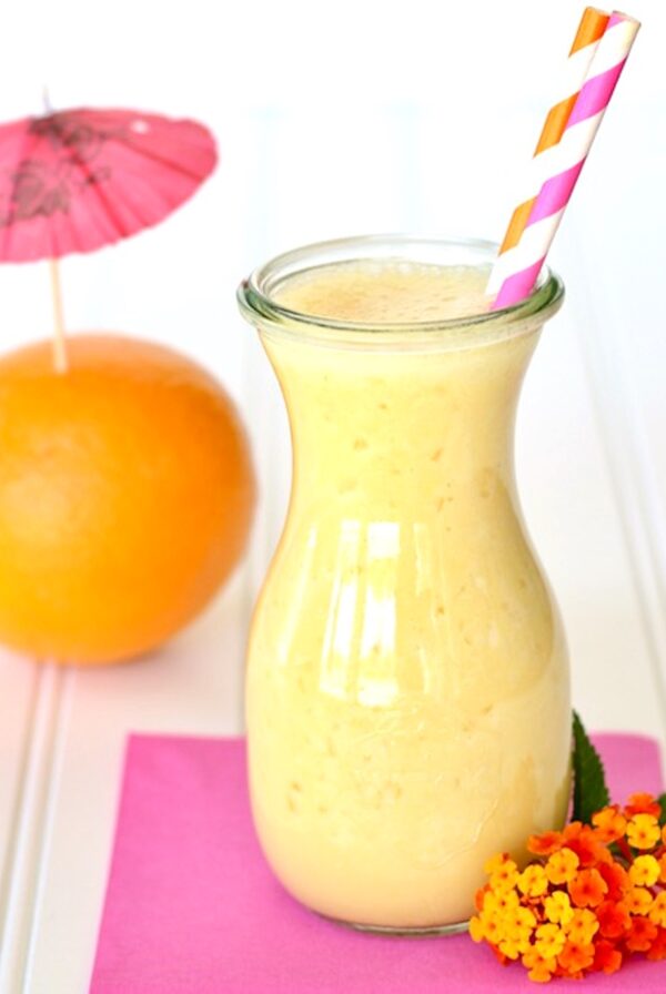 Orange Julius in jar with straws, and orange in the background.