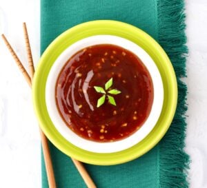 Pineapple Teriyaki Sauce in dish garnished with green onions, and chopsticks to the side.