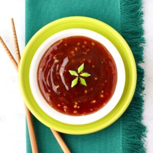 Pineapple Teriyaki Sauce in dish garnished with green onions, and chopsticks to the side.
