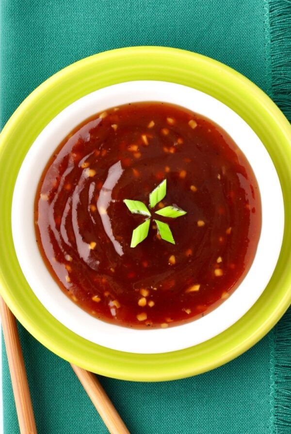 Pineapple Teriyaki Sauce in dish garnished with green onions, and chopsticks to the side.