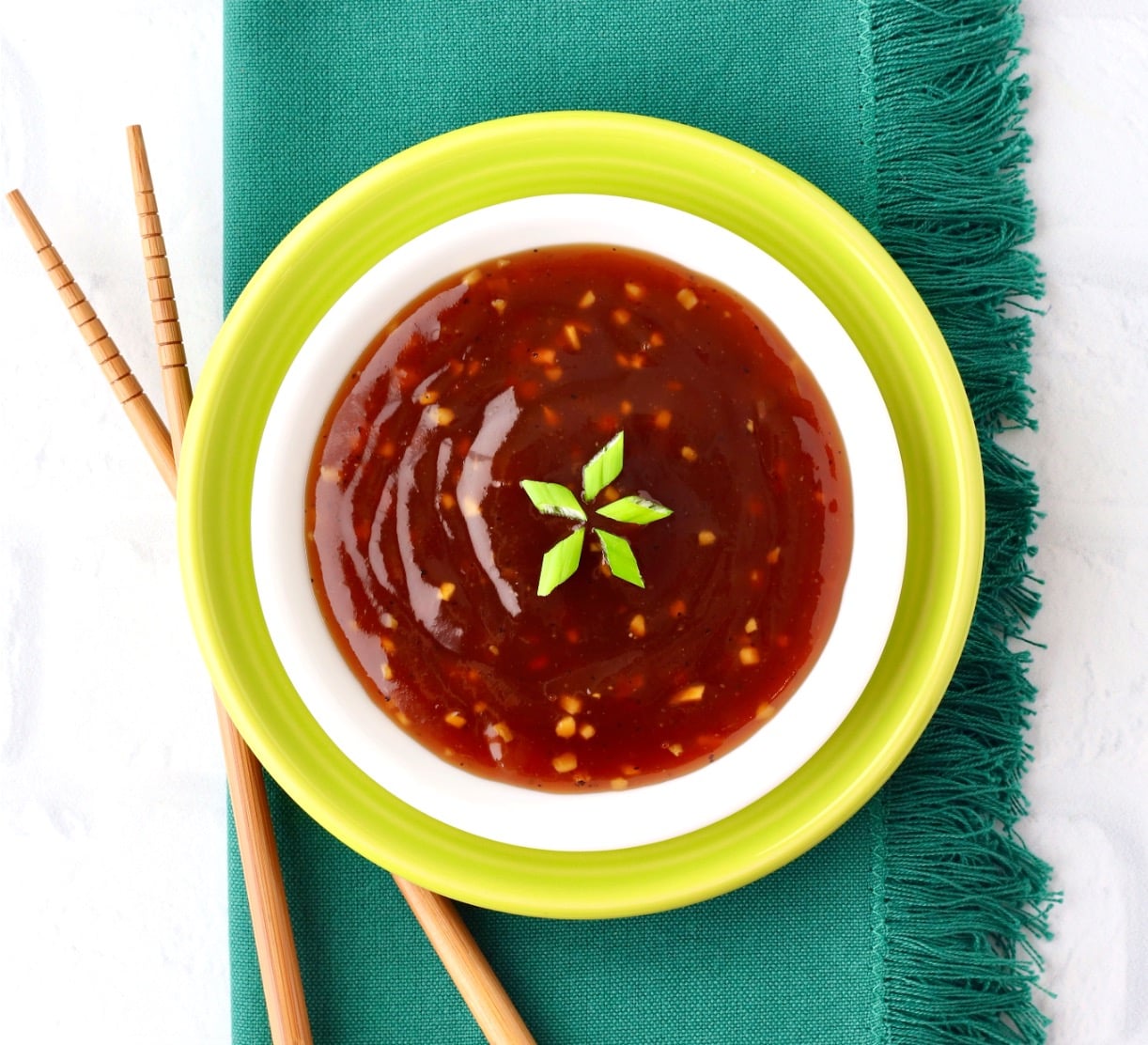 Pineapple Teriyaki Sauce in dish garnished with green onions, and chopsticks to the side.