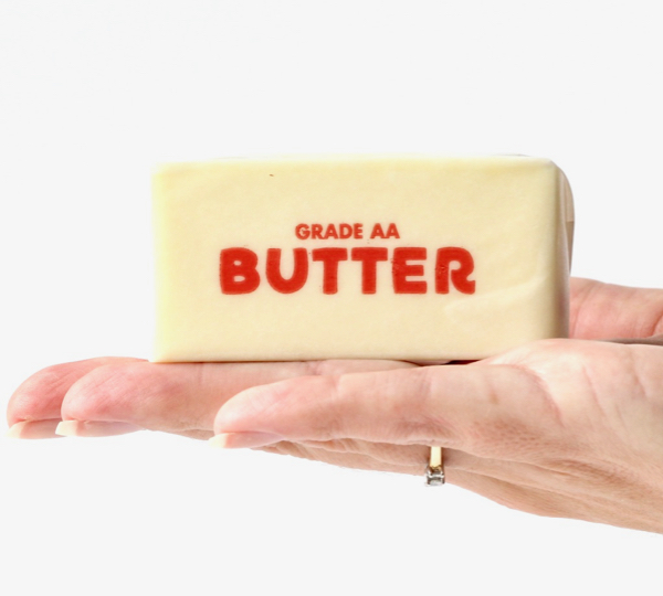 Hand holding a stick of butter.