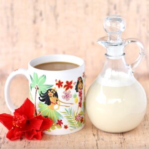 Homemade vanilla coffee creamer in glass container next to mug with coffee.