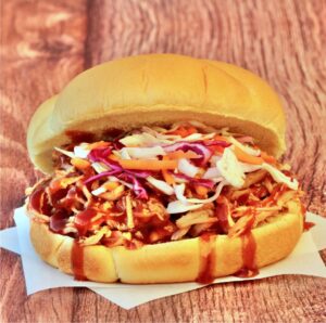 BBQ pulled pork sandwich with coleslaw on hamburger bun.