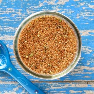 Homemade blackened seasoning mix in small mason jar with teaspoon to the side.