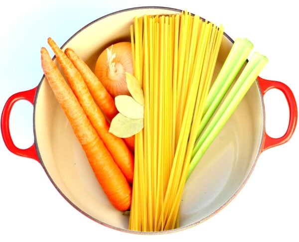 Ingredients for homemade chicken noodle soup in pot.