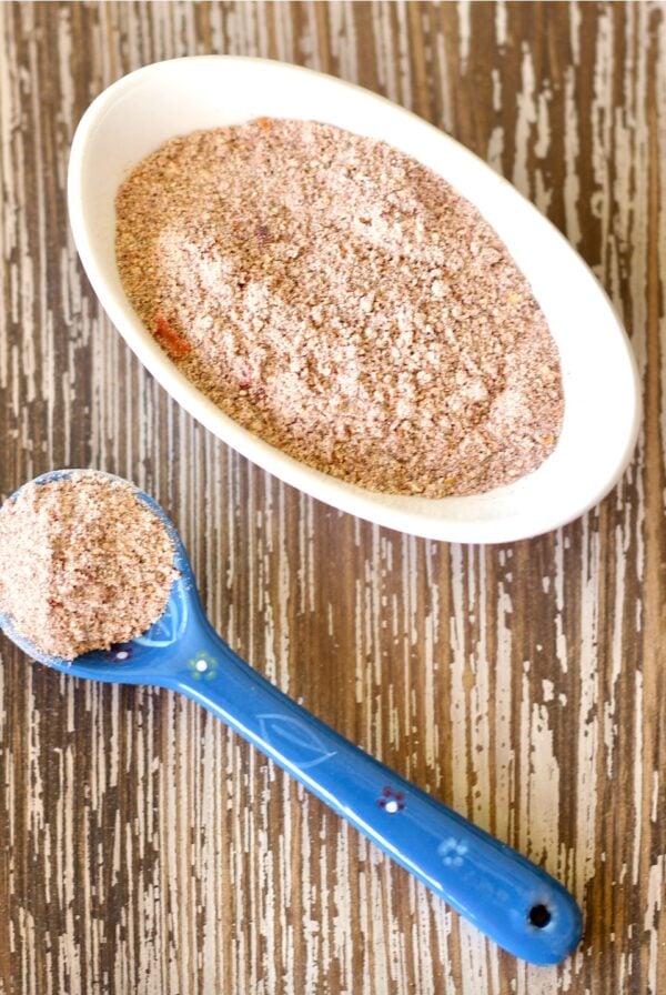 Homemade fajita seasoning in small dish with teaspoon to the side.