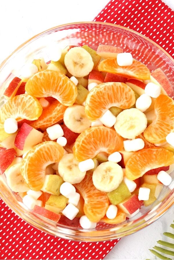 Fruit salad with oranges, apples, pears, bananas and mini marshmallows in bowl.