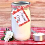 Homemade pancake mix in mason jar with measuring cup to the side.