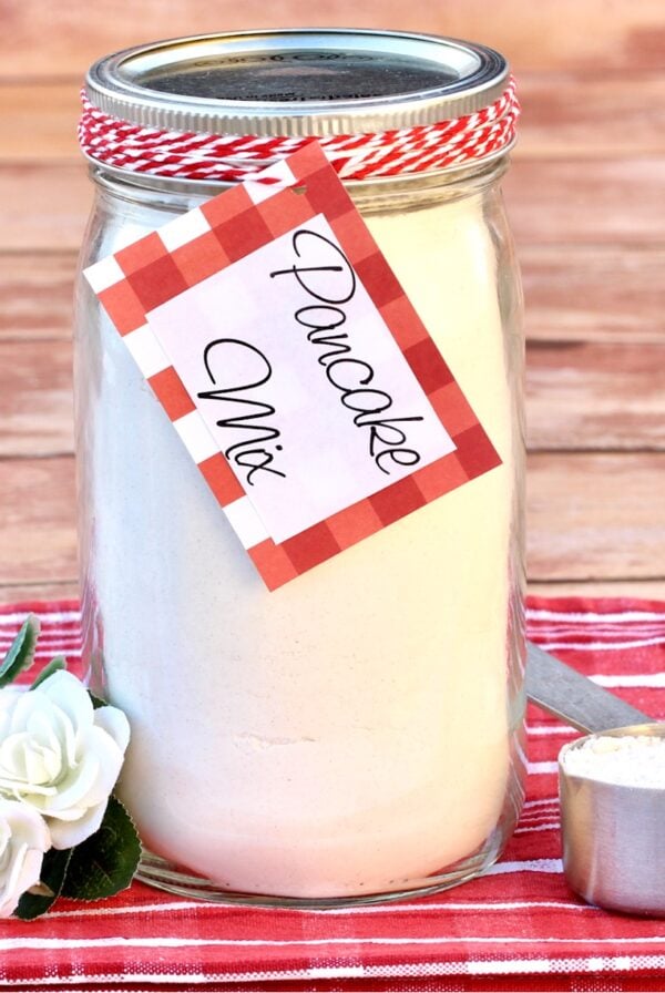 Homemade pancake mix in mason jar with measuring cup to the side.
