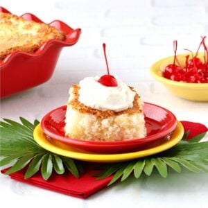Slice of pineapple angel food cake with whip cream and a cherry on top.