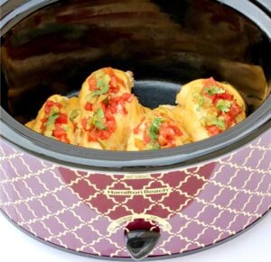 Four pieces of queso chicken in crockpot.