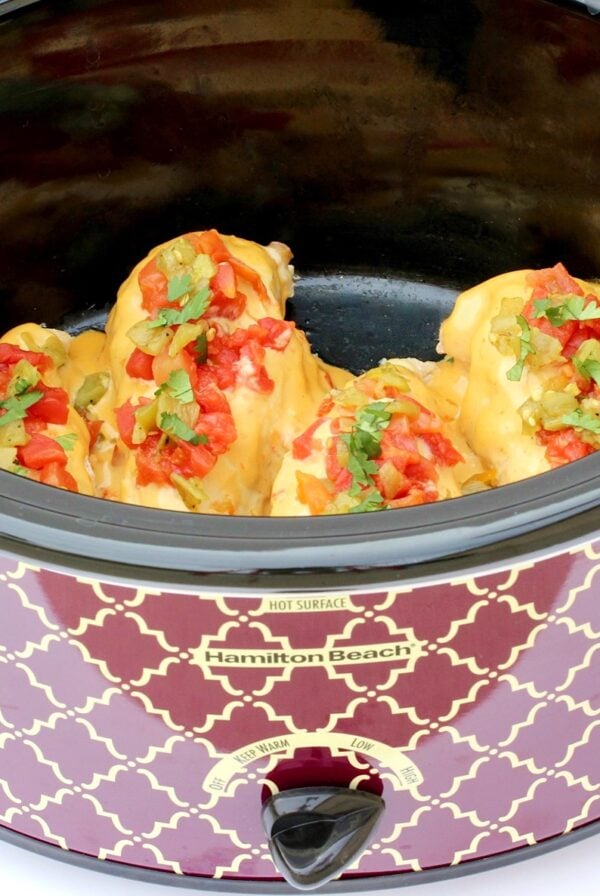 Four pieces of queso chicken in crockpot.