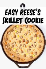 Cast iron skillet cookie with Reese's Pieces and chocolate peanut butter cups.