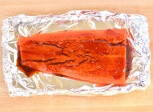 Salmon with teriyaki sauce on foil.
