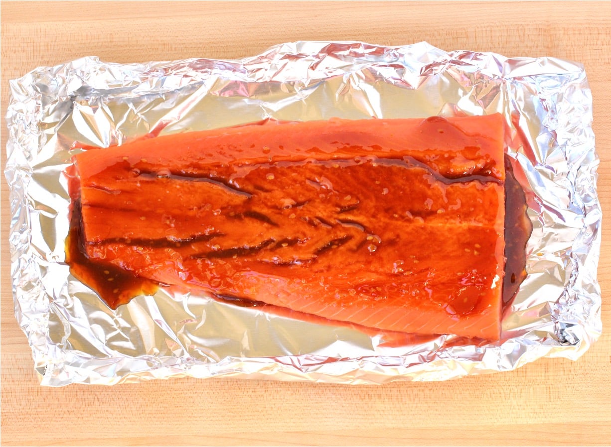 Salmon with teriyaki sauce on foil.