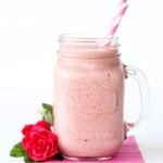 Strawberry Julius in mason jar mug with two straws.