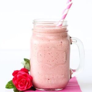 Strawberry Julius in mason jar mug with two straws.