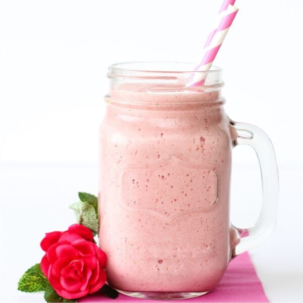Strawberry Julius in mason jar mug with two straws.