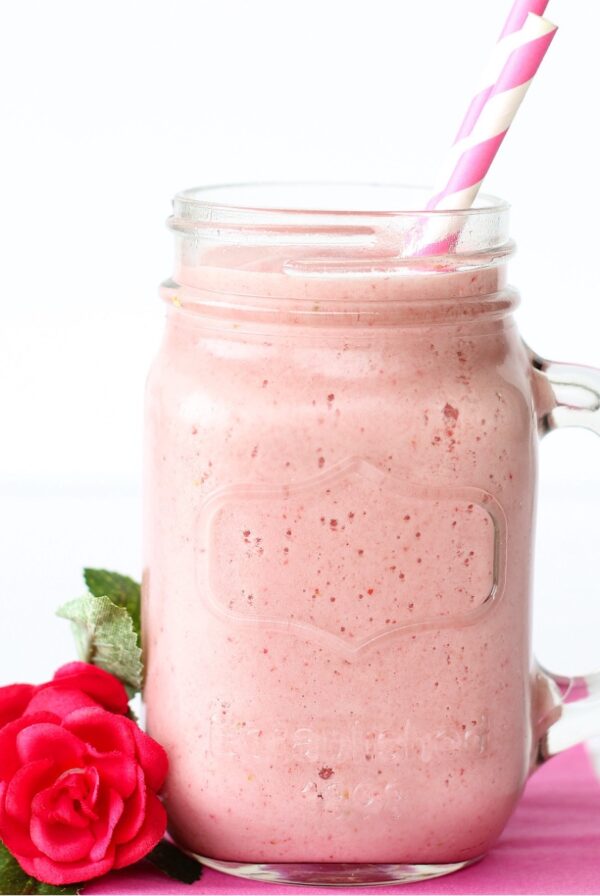 Strawberry Julius in mason jar mug with two straws.