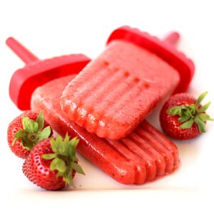 Two strawberry popsicles with fresh strawberries to the side.