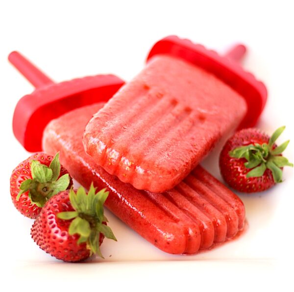 Two strawberry popsicles with fresh strawberries to the side.