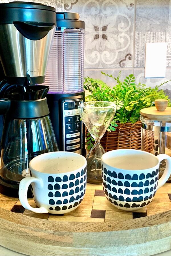 Coffee maker, French press, and 2 mugs on kitchen counter coffee bar tray.