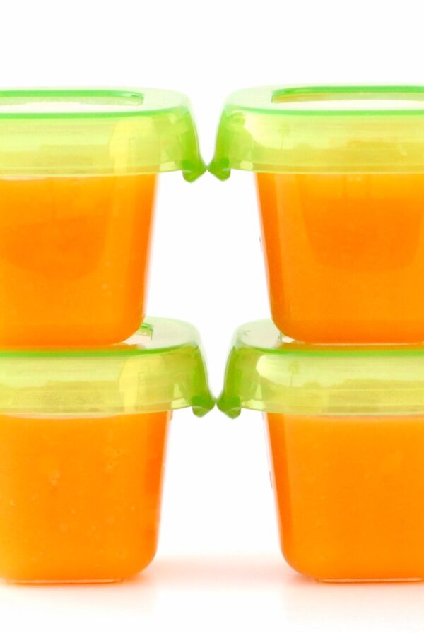 Four small containers of homemade butternut squash baby food puree.