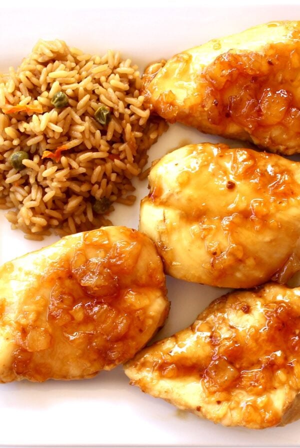 Four pieces of Chinese Mandarin Chicken on plate with rice.