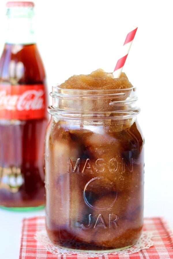 Frozen coke in mason jar with Coca-Cola bottle in the background.