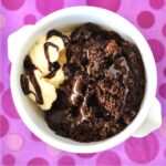 Chocolate lava cake in bowl with vanilla ice cream.