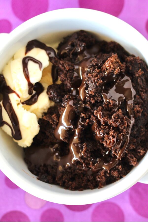 Chocolate lava cake in bowl with vanilla ice cream.