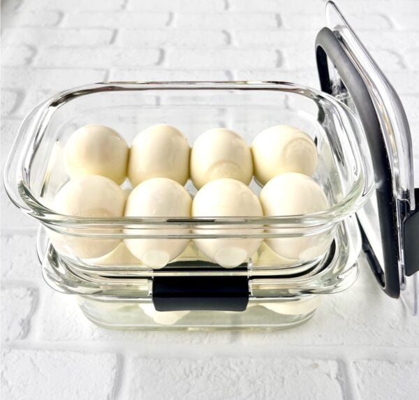 Peeled hard boiled eggs in meal prep containers.