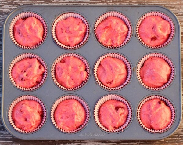 Strawberry cupcakes batter in cupcake liners, in muffin pan.