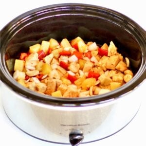 Sweet Chili Chicken with pineapple, onions, and bell peppers in crockpot.