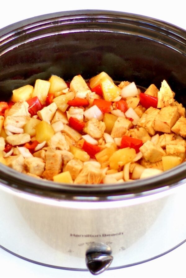 Sweet Chili Chicken with pineapple, onions, and bell peppers in crockpot.