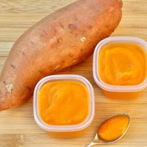 Sweet potato baby food in two containers, with sweet potato to the side.