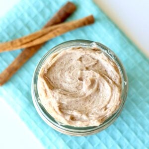 Cinnamon sugar butter in small mason jar with cinnamon sticks to the side.