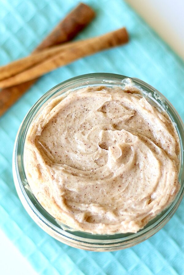 Cinnamon sugar butter in small mason jar with cinnamon sticks to the side.