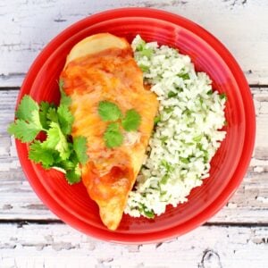 Enchilada Chicken with side of rice on plate.